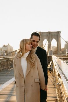 a man and woman are standing on a bridge