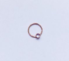 a gold ring with a single stone on it's side, against a white background