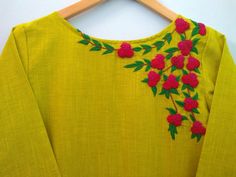 a yellow top with red flowers and green leaves