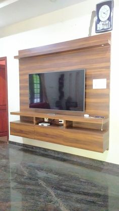 a flat screen tv sitting on top of a wooden entertainment center in a living room