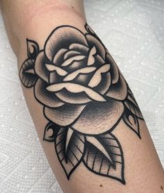 a black and white rose tattoo on the arm