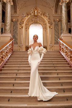 a woman in a white dress standing on some stairs