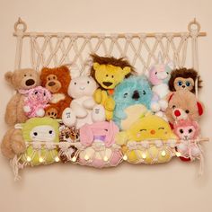 a group of stuffed animals sitting on top of a shelf with string lights around them