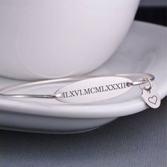 The bangle is hand formed from heavy gauge sterling silver wire and then hand-hammered and tumbled for shine and strength. A stainless steel oval measuring 1 1/4 inch across is engraved with the Roman Numeral of your choice. Unsure of the roman numeral for your date? Just let me know the date in the text box and I will look it up. **ALL CHARMS ARE OPTIONAL. Swarovski crystal birthstone charms and initial charms are optional. Just choose the option when adding to your cart! 1 charm = one initial Bracelet For Mom, Roman Numeral Bracelet, Bracelet Size Chart, Rose Gold Bangle, Personalized Anniversary Gifts, Custom Bracelet, Sterling Silver Bangle Bracelets, Bangles Style, Mom Jewelry