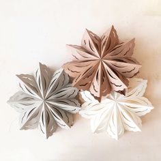 three paper snowflakes sitting next to each other