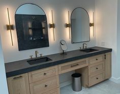 a bathroom with double sinks and mirrors on the wall