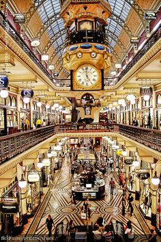 the inside of a shopping mall with people walking around