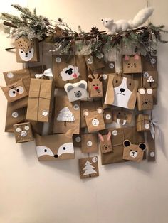 brown paper bags with animals on them are hanging from a wall and decorated with evergreen branches