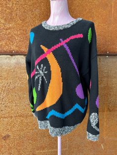 Classic 1980s Esprit Sport cotton crew neck oversized sweater features bright graphic shapes of circles, moon, starburst, squiggles and music notes on a rich black ground. The crew neck, cuffs, and rib hem are in a black and white marled yarn. Easy to wear oversized style. Very good vintage condition, no signs of wear, holes or fading. Measurements are taken with garment flat in inches Bust pit to pit relaxed 46 Waist edge to edge relaxed 39 Shoulder seam to Shoulder seam 25 Sleeve Length - Shou Art Mom Aesthetic, Outfit Reference, Graphic Shapes, 80's Fashion, Black Ground, 80s Sweater, 80s Outfit, Oversized Style, Pullover Sweater Women