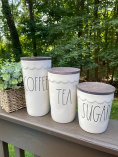 three white coffee cups sitting on top of a wooden table