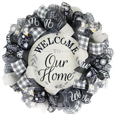 a welcome wreath with the words welcome to our home in black, white and gray