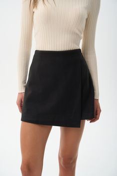 A classic mini skirt-short hybrid is a versatile piece in any woman's wardrobe. It offers a stylish and attractive look while maintaining comfort and freedom of movement. The minimalist design provides ample opportunity for varied styling options. To balance the short length, pair it with low-heeled shoes and a modest, closed-top. This combination highlights the beauty of your legs while keeping the overall look balanced and chic. Relaxed Mini Skort With Built-in Shorts, Elegant Mini Skirt With Built-in Shorts, Modern Skirt With Asymmetrical Hem For Work, Chic Mini Skirt With Built-in Shorts And Flowy Fit, Spring Asymmetrical Skort With Built-in Shorts, Elegant Mini Skort With Built-in Shorts, Relaxed Mini Skirt With Built-in Shorts, Elegant Mini Skirt With Built-in Shorts For Work, Elegant Fitted Mini Skirt With Built-in Shorts