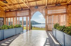 the inside of a wooden building with windows and plants