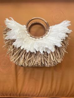 "One of One. Handmade Balinese Handbag Basket. Beautiful basket for a fun night on the town or brunch with your friends. The basket is made from straw, feathers, and shells. It has a lining on the inside to protect your items from dust and damage. Fits many personal items. Also, a wonderful accessory for the beach or pool. Size: 12\" tall x 4\" deep x 10\" wide" Summer Beach Bags Made Of Shell, Summer Beach Bags With Shell Material, Bali Elephant, Bali Decor, Hair Extension Clips, Elephant Sanctuary, One Of One, Straw Handbags, Top Handle Bags