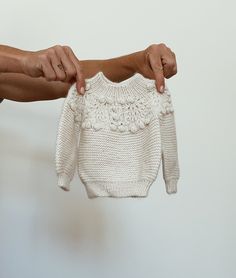 Welcoming Winnie into the fold. Our Winnie sweater is lovingly hand knit in the softest baby alpaca - perfect for your little ones precious skin. Our Winnie sweater is our modern take on a vintage matinee gown. The garter stitch compliments the yoke detailing by balancing the overall look, resulting in a timeless, gender neutral design. Pop Winnie on with your Fern pants and pair with our Barbara bonnet and Dudley booties for the ultimate in winter warmth. Handmade White Knit Sweater, Fitted White Merino Wool Sweater, White Hand Knitted Fitted Knitting Pattern, Fitted White Hand Knitted Pattern, Fitted White Hand-knitted Pattern, Fitted Cream Knitted Sweater, Cream Fitted Knitted Sweater, Cozy Cream Crochet Sweater, Cream Knitted Alpaca Sweater