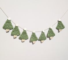 small crocheted christmas trees hanging on a string