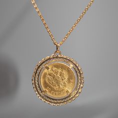 This pendant features a 1899 10 Roubles Russian Empire solid 14k yellow gold coin that displays Tsar Nicholas II in a 14k yellow gold setting. Materials: 14k yellow gold Pendant Size: 38.5mm from bottom of pendant to top of bail Comes with a 32 inch 14k yellow gold cable chain Tsar Nicholas II, the last Emperor of Russia, reigned from 1894 until his abduction in 1917. The coin of Nicholas II feature his portrait on the obverse, displaying his likeness in intricate detail. The reverse side showca Victorian Necklace With Coin Pendant For Formal Occasions, Vintage Yellow Gold Round Pendant Coin Necklace, Vintage Yellow Gold Coin Necklace With Round Pendant, Collectible Yellow Gold Filigree Necklaces, Yellow Gold Coin Pendant Necklace, Yellow Gold Filigree Necklaces, Antique Engraved Yellow Gold Coin Necklace, Victorian Gold Jewelry With Coin Pendant, Yellow Gold Coin Pendant Medallion Jewelry