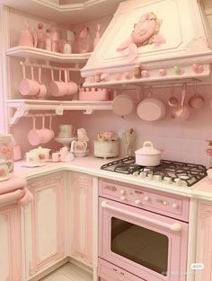 a pink kitchen with lots of pots and pans