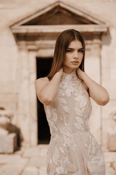 a woman in a wedding dress posing for a photo with her hand on her head