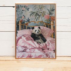 a panda bear laying on top of a bed covered in pink sheets