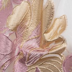 the fabric has been stitched together with gold and pink flowers on it, as well as leaves