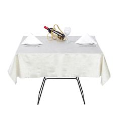 the table is set with two wine glasses and one empty bottle on top of it