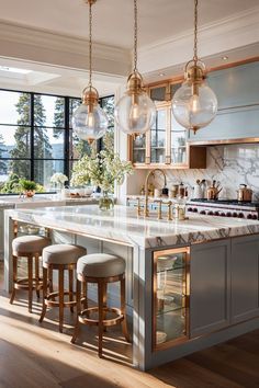 a large kitchen with marble counter tops and gold trimming on the cabinets, along with stools