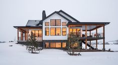 a large white house sitting on top of a snow covered field