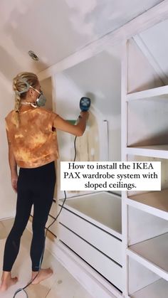 a woman using a paint sprayer on the wall in her room with text overlay that reads, how to install the ikea pax wardrobe system with carpet clings