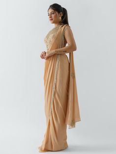 A two-piece peach saree set from the Suruchi Parakh collection. This beautiful pre drape saree is paired with a hand-crafted blouse. The pallu of the pre draped saree has hanging tassels to it. The peach color touch enhances the graceful georgette crepe pre drape saree. The peach blouse has a crew neckline along with geometrical & floral handwork detail. Silk Anarkali Saree With Draped Style, Resham Embroidery Saree With Side Open, Draped Chanderi Saree With Dupatta, Traditional Peach Pre-draped Saree With Zari Work, Traditional Pre-draped Saree With Dupatta, Anarkali Silk Saree, Elegant Draped Sharara With Cutdana, Pre-draped Tissue Silk Saree With Dupatta, Bollywood Style Draped Tissue Silk Dupatta