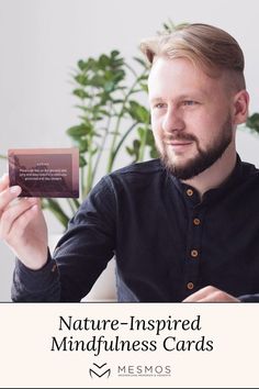 a man holding up a card that says nature - inspired mindfulness cards