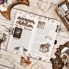 an open book sitting on top of a wooden table next to other items and decorations