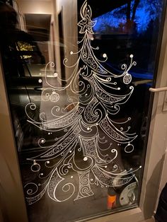 a christmas tree etched into a glass door