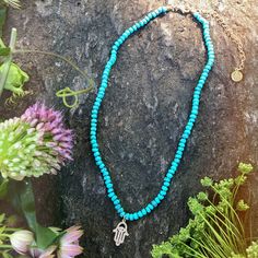 Turquoise is called the self acceptance stone. It promoted self-esteem and unconditional love. Our hand beaded necklace also has a Hamsa charm pendant in goldtone plated brass with cubic zirconia stones. The Hamsa symbol dates back to ancient Mesopotamia where the open right hand is seen in artifacts and in the amulets of the goddess Ishtar. Other symbols of divine protection based around the hand include the Hand-of-Venus which was used to protect women from the evil eye and/or boost fertility, Holistic Turquoise Necklaces With Natural Stones, Adjustable Spiritual Turquoise Necklace For Meditation, Turquoise Pendant Beaded Necklace For Meditation, Bohemian Turquoise Evil Eye Necklace, Handmade Turquoise Spiritual Necklace, Spiritual Turquoise Necklaces For Festivals, Spiritual Turquoise Necklace For Meditation, Handmade Blue Turquoise Necklace For Meditation, Handmade Turquoise Beaded Necklaces For Meditation