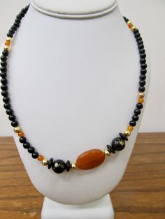 - Vintage black and orange plastic beaded necklace - Small round with larger accent beads - 50 inch necklace - Clean and in good condition K 3304 Vintage Orange Beaded Necklaces With Oval Beads, Black Necklaces With Colorful Oval Beads, Adjustable Orange Necklaces With Black Beads, Vintage Black Beaded Necklace With Gemstone Beads, Black Vintage Beaded Necklaces With Colorful Beads, Black Oval Beaded Necklaces, Orange Necklace With Black Round Beads, Vintage Black Beaded Necklace With Colorful Beads, Black Necklace With Colorful Oval Beads