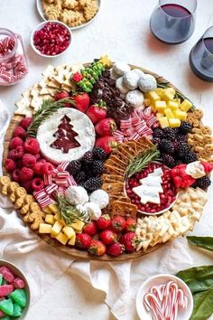 a platter filled with fruit, crackers and pretzels on a table