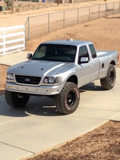 a silver truck parked on top of a sidewalk