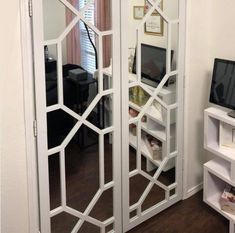 a white room with mirrored doors and a television on the stand in front of it