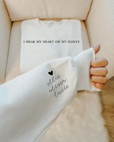 a woman's arm wrapped around a white t - shirt that says i wear my heart on my sleeve