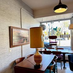 a lamp is sitting on top of a table in a room with chairs and tables