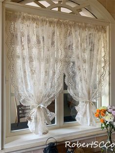 the window is decorated with white lace and bowknots, as well as flowers