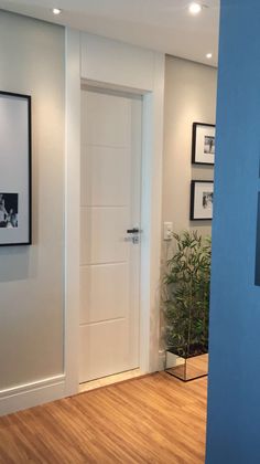 an empty room with blue walls and pictures on the wall, along with wooden floors