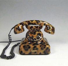 an animal print phone is shown on a white surface with a cord in the foreground