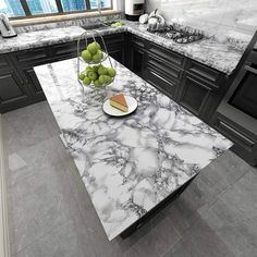 a marble counter top in a kitchen with black cabinets and white walls, along with fruit on a plate