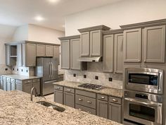 a large kitchen with granite counter tops and stainless steel appliances in the middle of it