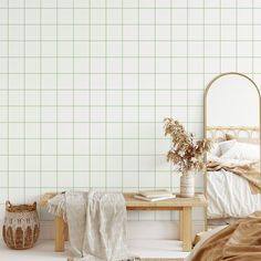 a bedroom with a bed, table and plant on the floor in front of it