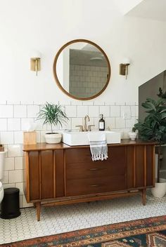 a bathroom with a sink, mirror and rug on the floor in front of it