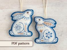 two blue and white bunny ornaments hanging from strings