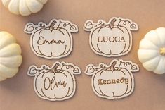 pumpkin cutouts with names on them sitting next to white pumpkins