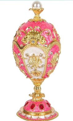 a pink and gold vase with pearls on top